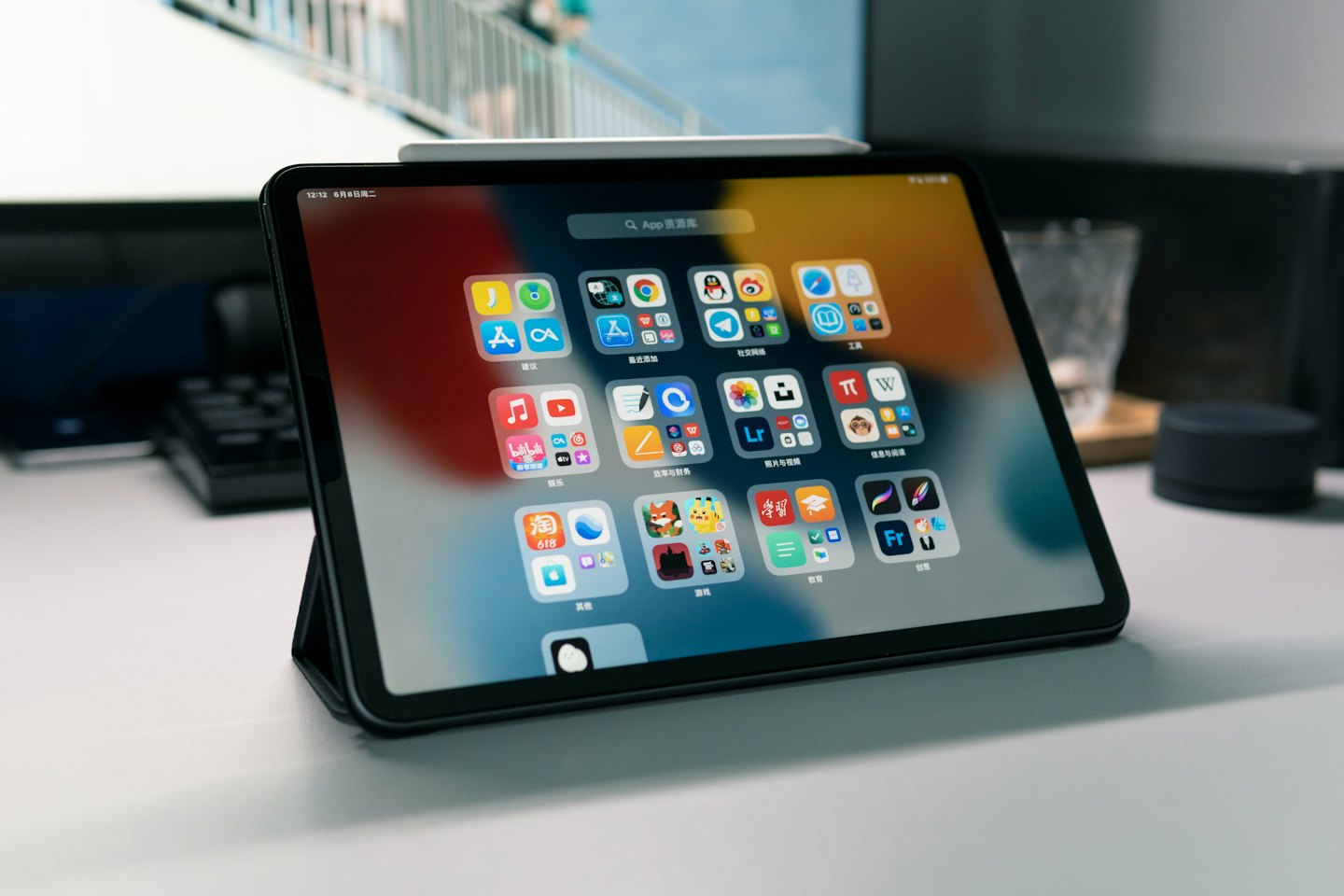 Tablet with colorful app icons rests on a white desk.